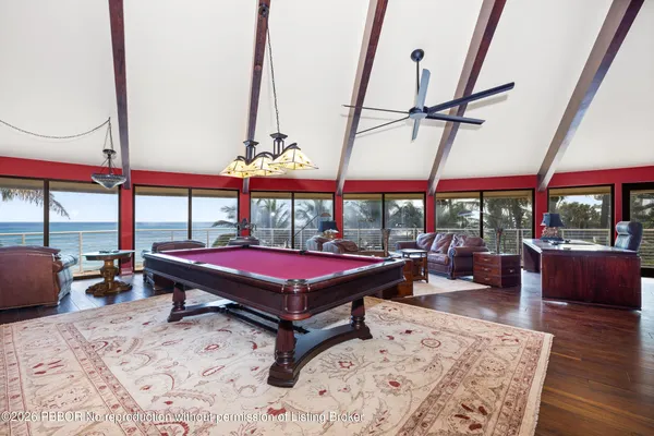 a living room with furniture a flat screen tv and a floor to ceiling window