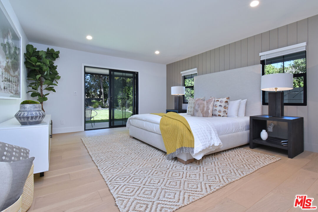 2037 Stradella Road Los Angeles, CA 90077 - Photo 12 of 33 a spacious bedroom with a bed a couch and a potted plant
