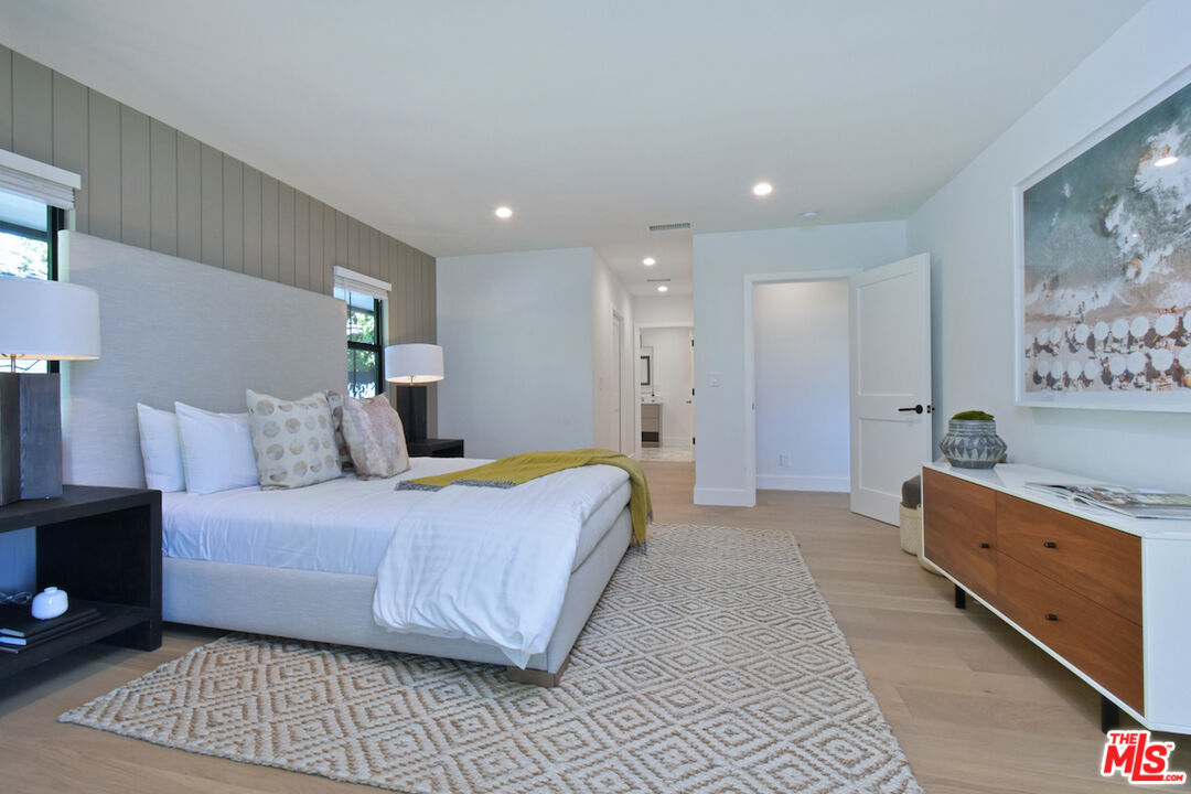 2037 Stradella Road Los Angeles, CA 90077 - Photo 13 of 33 a spacious bedroom with a bed and a lamp on dresser