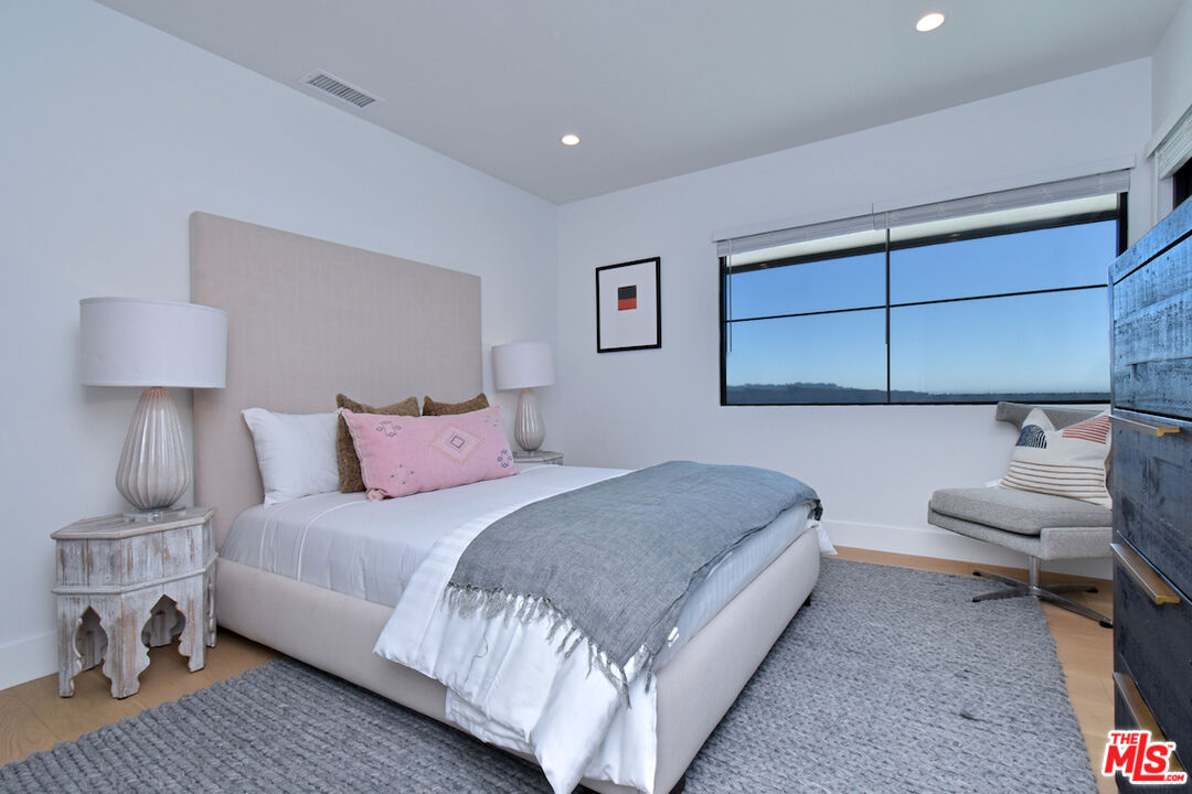 2037 Stradella Road Los Angeles, CA 90077 - Photo 18 of 33 a bedroom with a bed and a lamp