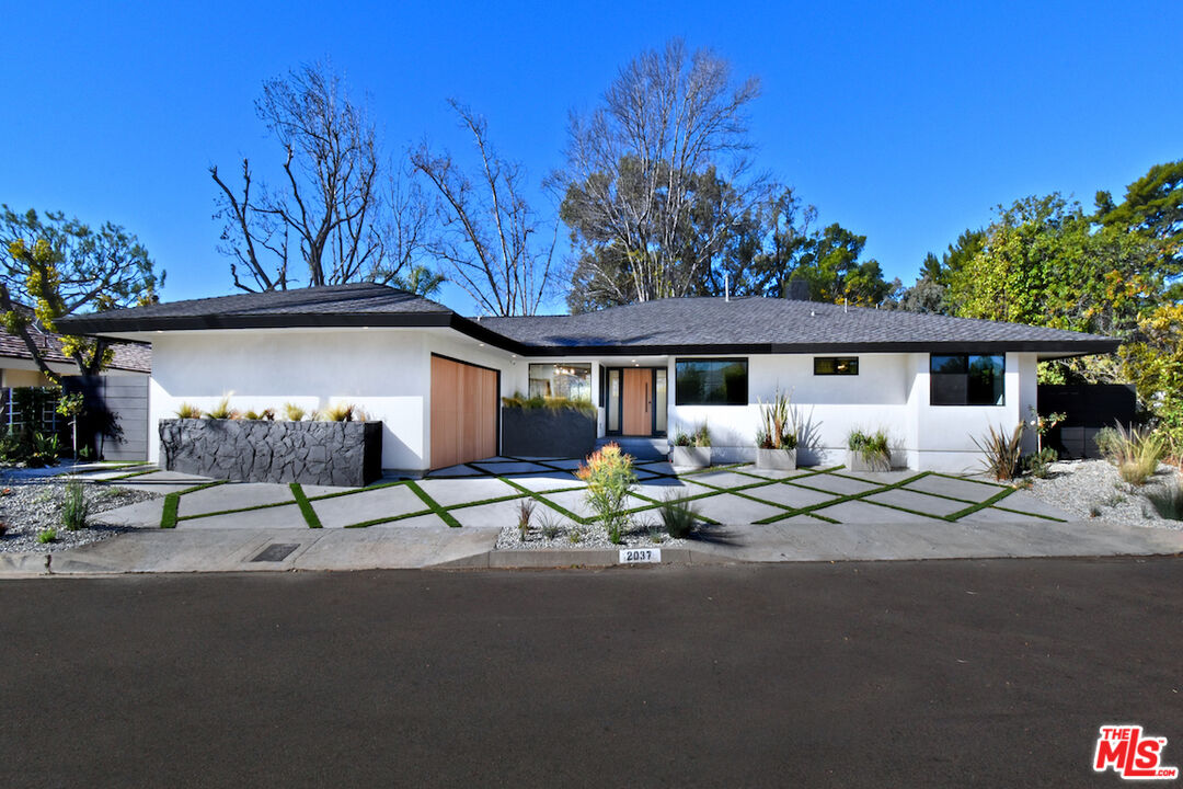 2037 Stradella Road Los Angeles, CA 90077 - Photo 3 of 33 a row of palm trees in front of a house
