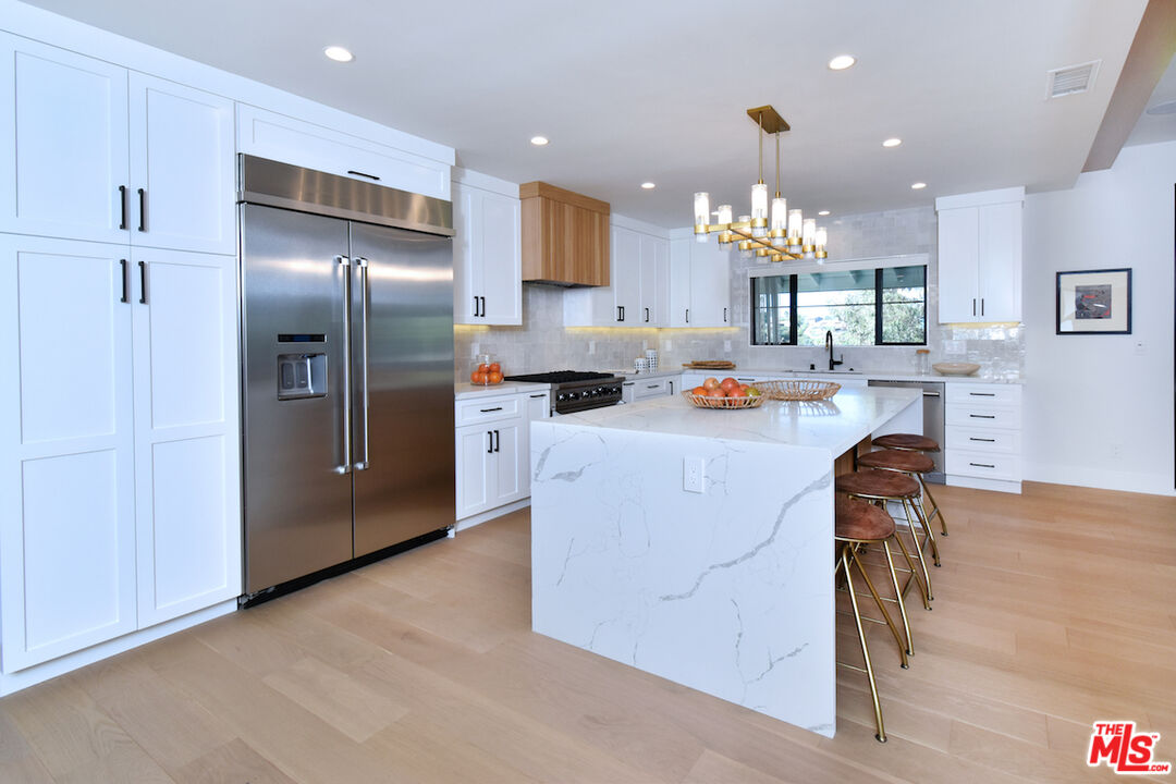 2037 Stradella Road Los Angeles, CA 90077 - Photo 9 of 33 a kitchen with stainless steel appliances granite countertop a refrigerator and a sink