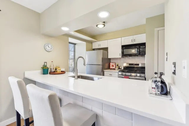 a kitchen with a sink a stove and chairs