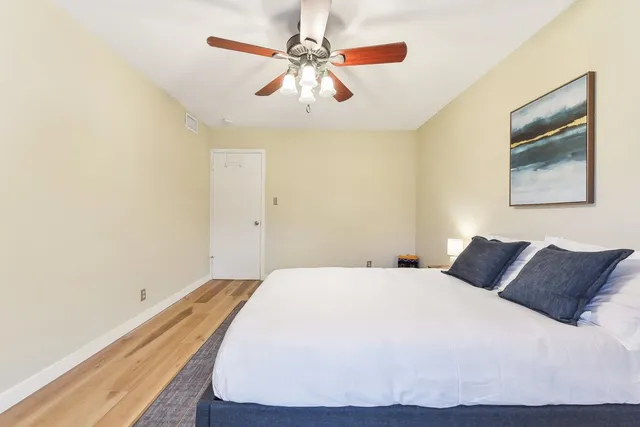 a bedroom with a bed and a painting on the wall