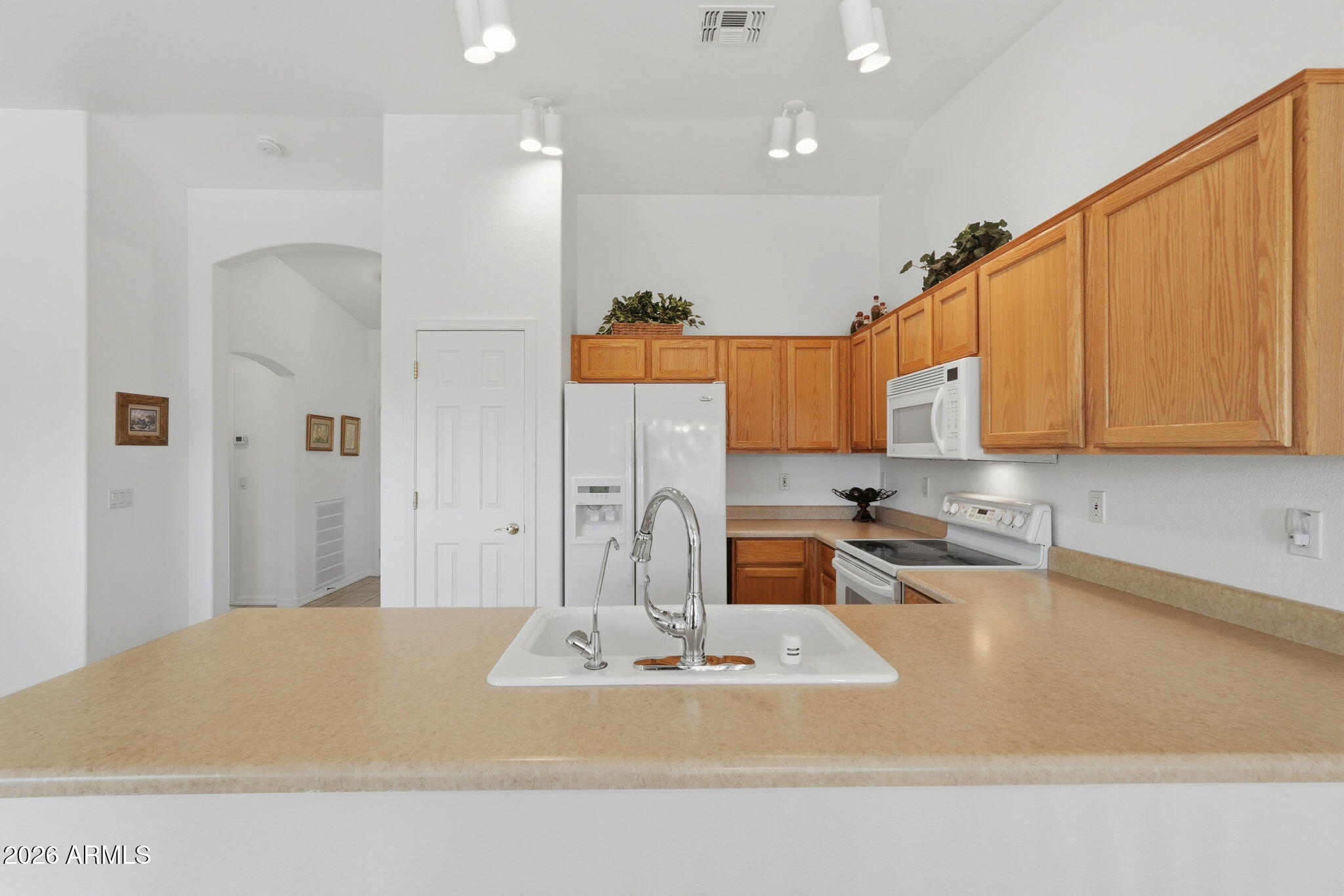 6317 South Pinaleno Place Chandler, AZ 85249 - Photo 12 of 45 a large kitchen with kitchen island granite countertop a sink and white cabinets