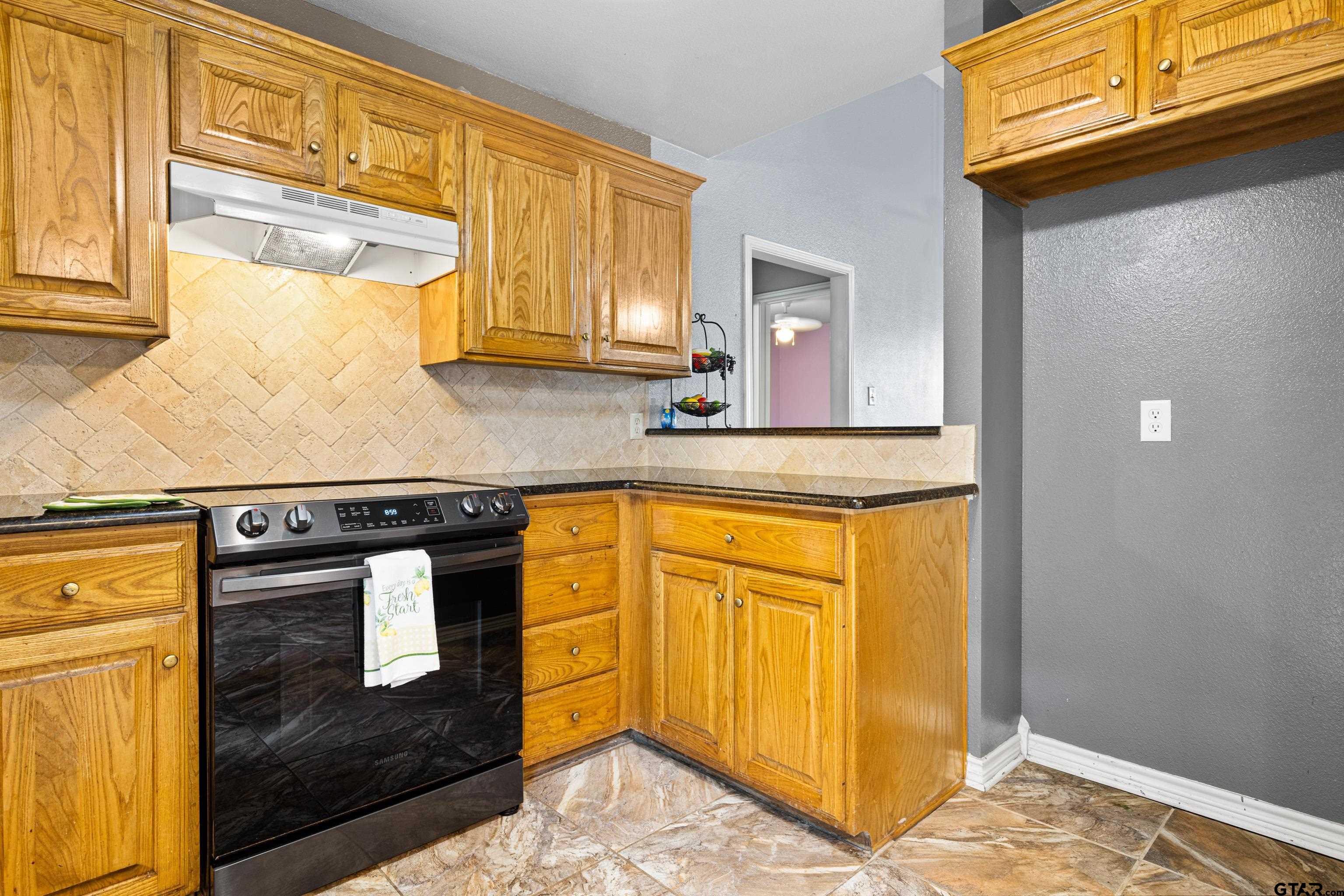 3631 Andrea Street Longview, TX 75604 - Photo 14 of 44 a kitchen with stainless steel appliances granite countertop a stove a sink and a microwave