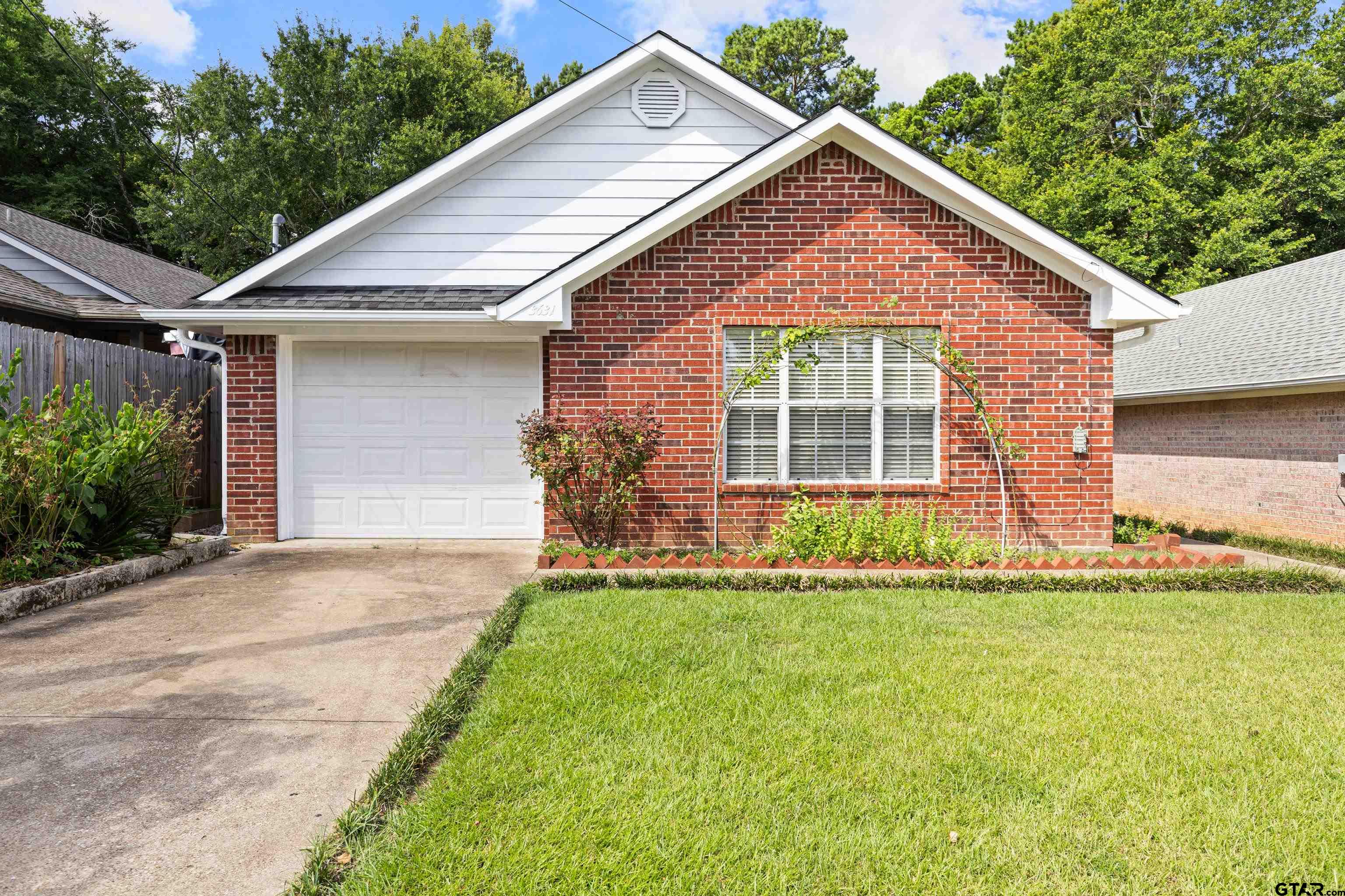3631 Andrea Street Longview, TX 75604 - Photo 3 of 44 a view of a yard in front of a house with plants and large tree