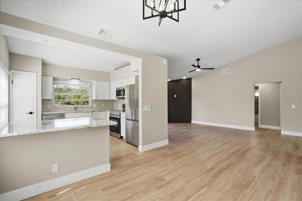 1723 Elk Spring Drive Brandon, FL 33511 - Photo 6 of 21 a view of a kitchen with a refrigerator wooden floor and a living room