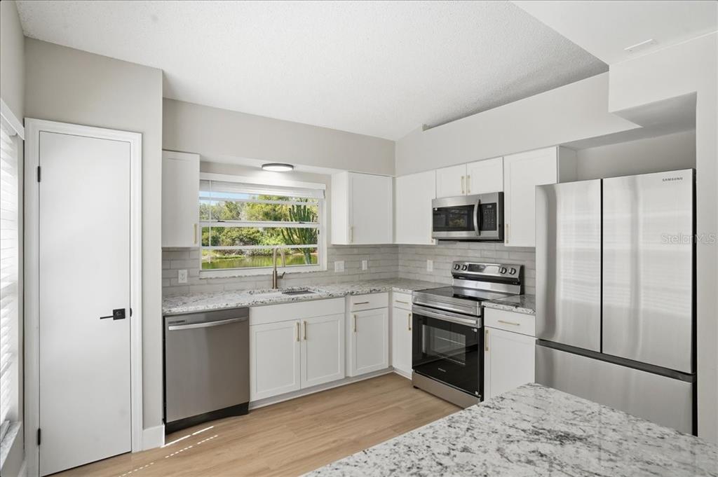 1723 Elk Spring Drive Brandon, FL 33511 - Photo 7 of 21 a kitchen with stainless steel appliances granite countertop a stove a sink and a refrigerator