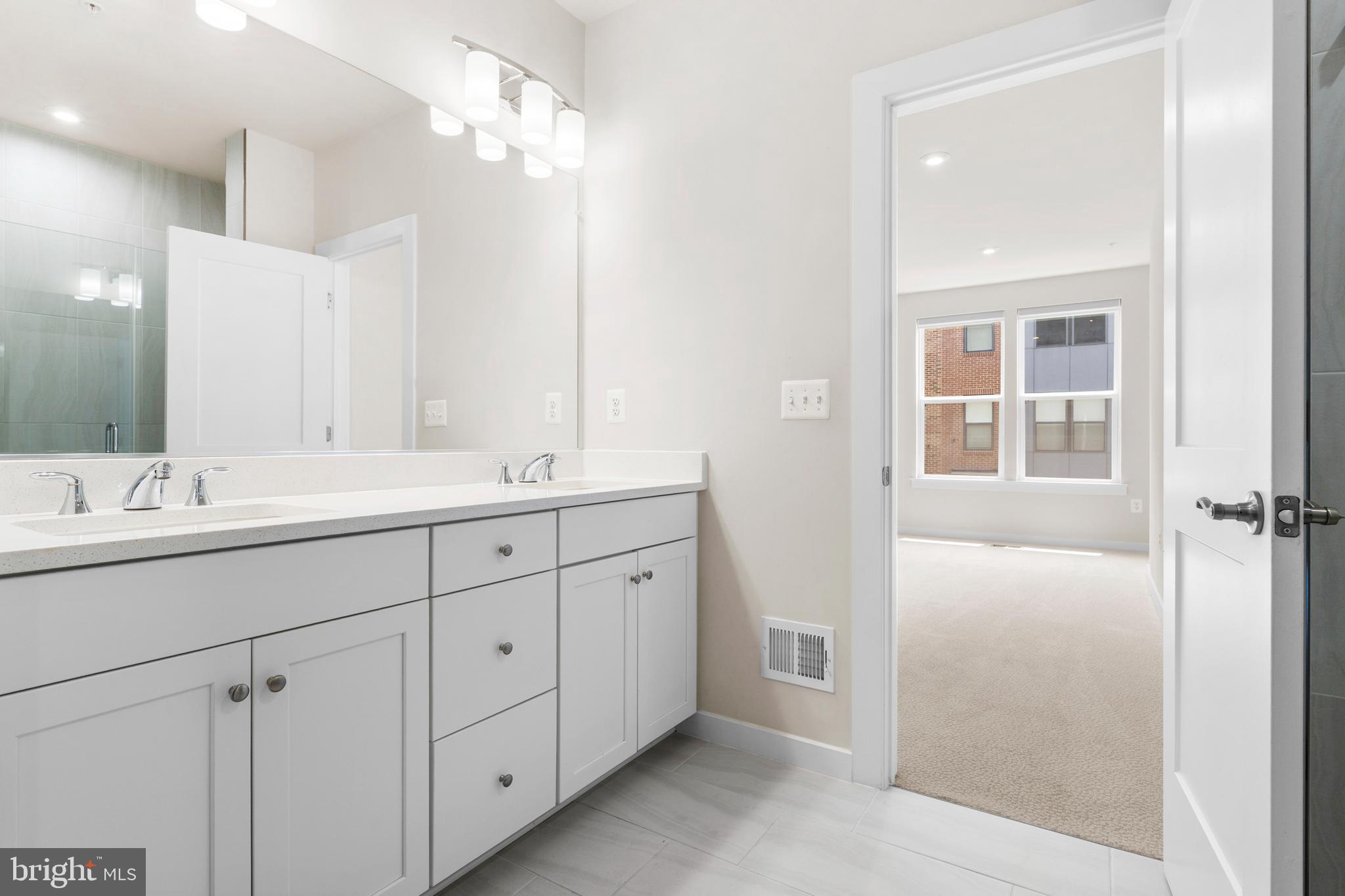 44487 Wolfhound Square Ashburn, VA 20147 - Photo 17 of 39 a bathroom with a double vanity sink and mirror