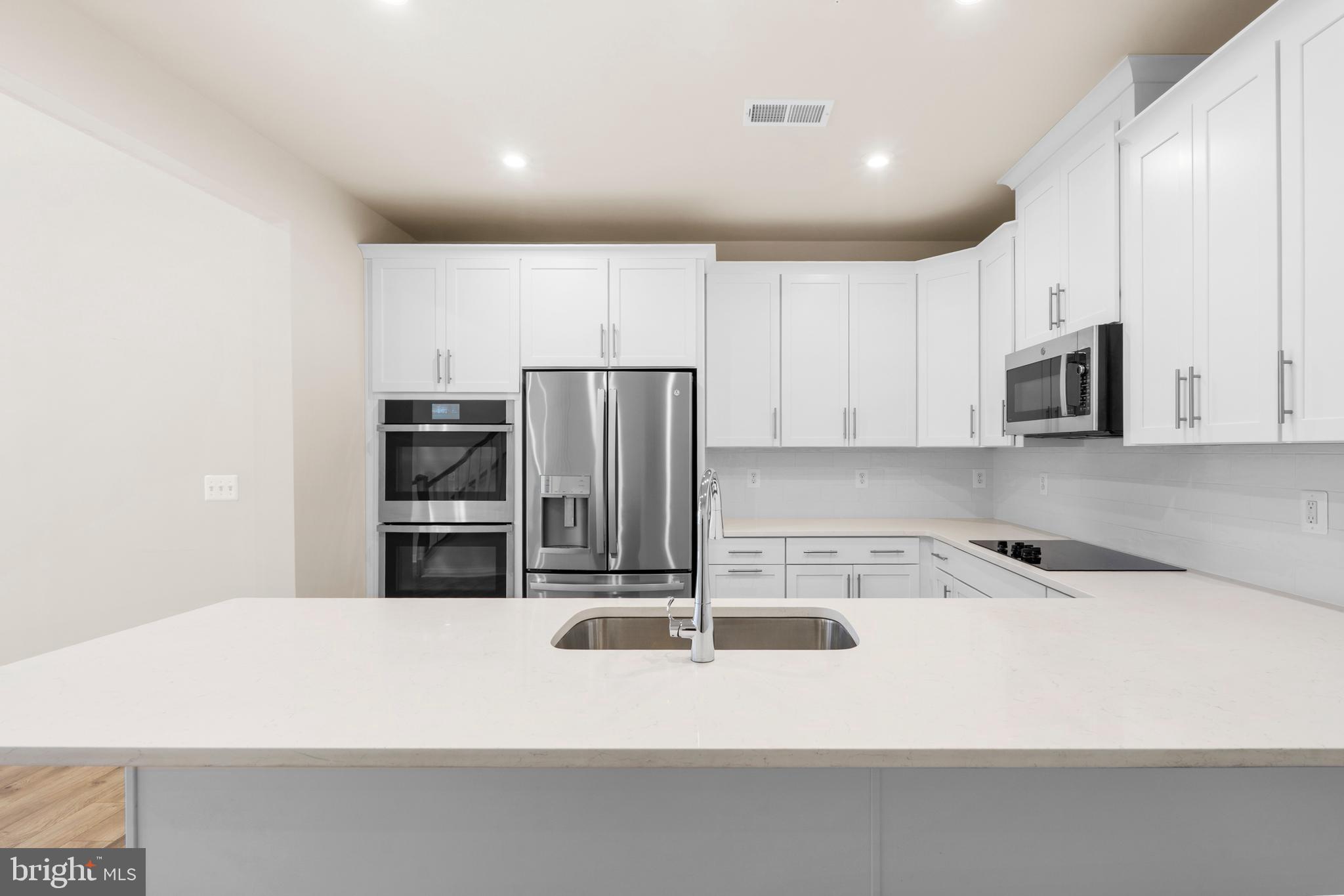 44487 Wolfhound Square Ashburn, VA 20147 - Photo 7 of 39 a kitchen with kitchen island a sink stainless steel appliances and cabinets