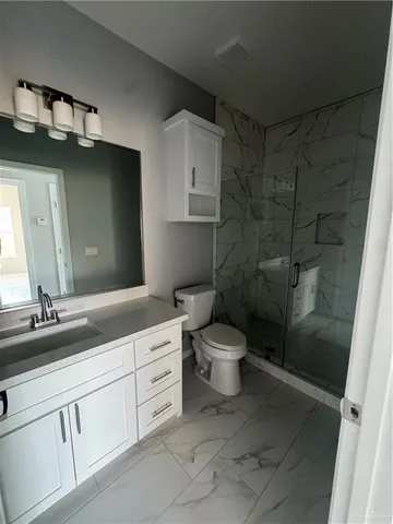 a bathroom with a double vanity sink toilet and shower