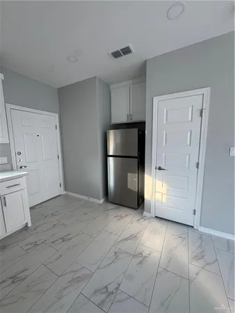 a view of a kitchen with a sink and a refrigerator
