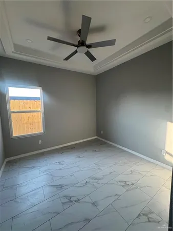an empty room with a ceiling fan and window