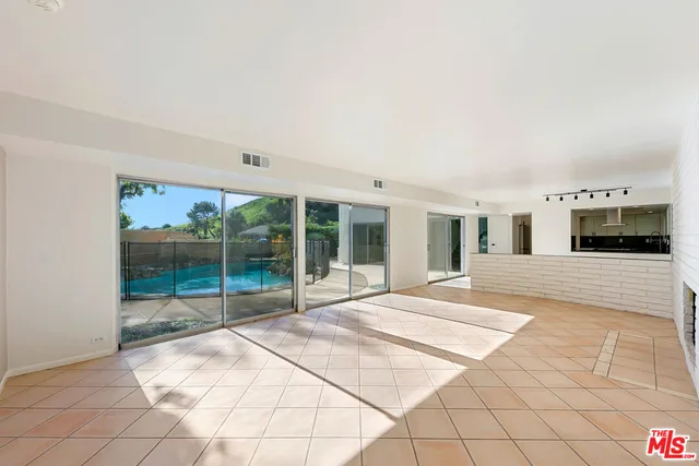 a view of a big room with windows and kitchen view
