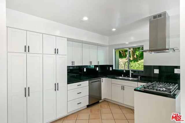 a kitchen with granite countertop a stove a sink and a microwave