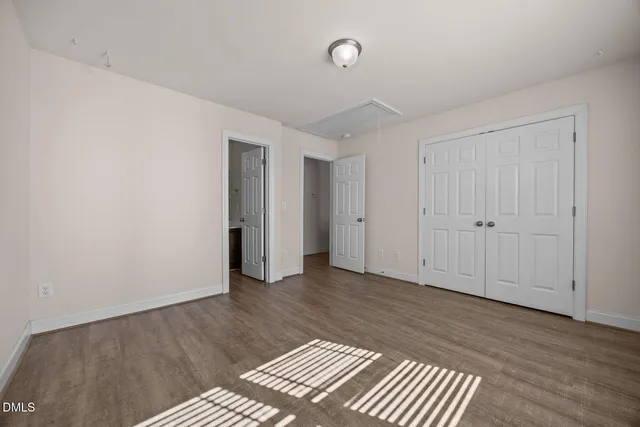 an empty room with wooden floor and closet
