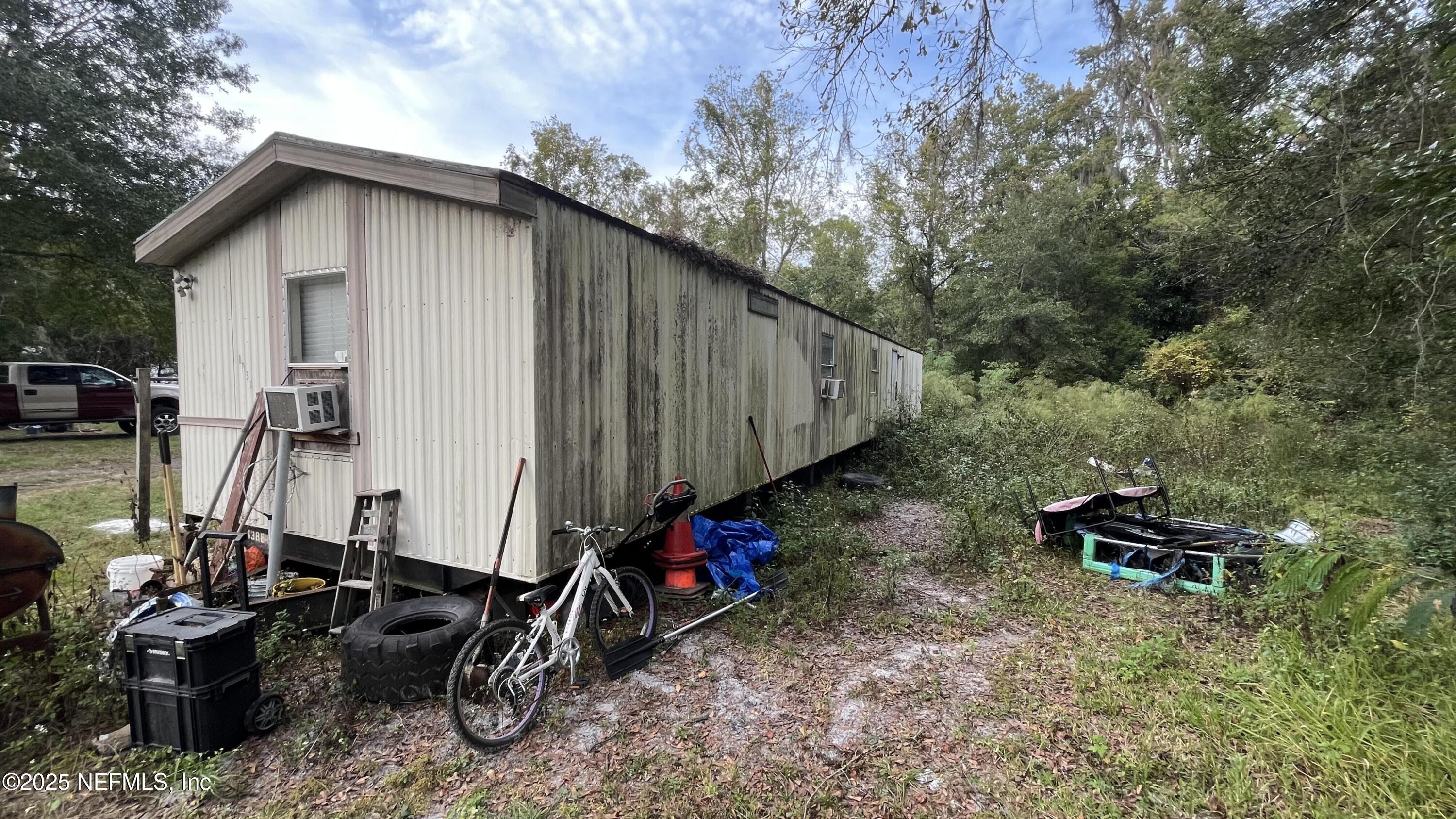 10017 Factory Avenue Hampton, FL 32044 - Photo 3 of 11 a view of a wooden house with a small yard and sitting area