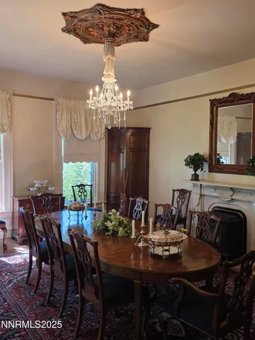 a view of a dining room with furniture a chandelier and window