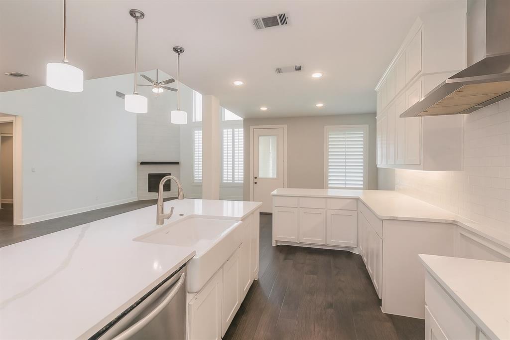 1908 Grey Bark Street Fort Worth, TX 76008 - Photo 5 of 31 Kitchen featuring white cabinetry, dark wood-style flooring, wall chimney range hood, pendant lighting, and recessed lighting