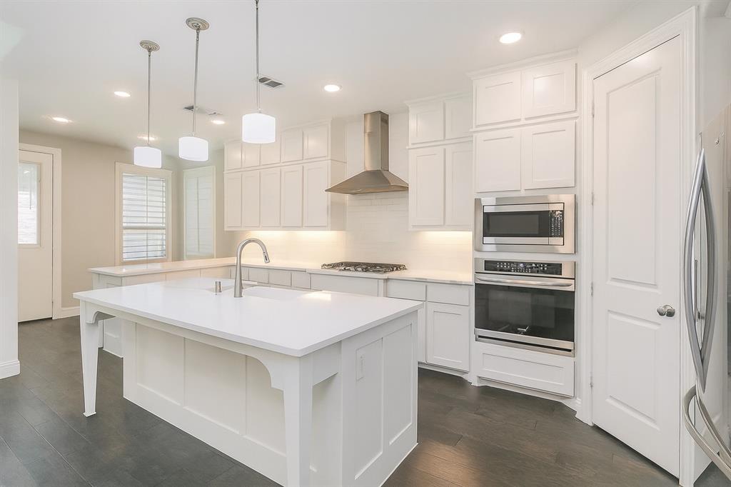 1908 Grey Bark Street Fort Worth, TX 76008 - Photo 7 of 31 Kitchen featuring appliances with stainless steel finishes, white cabinets, pendant lighting, wall chimney range hood, and recessed lighting