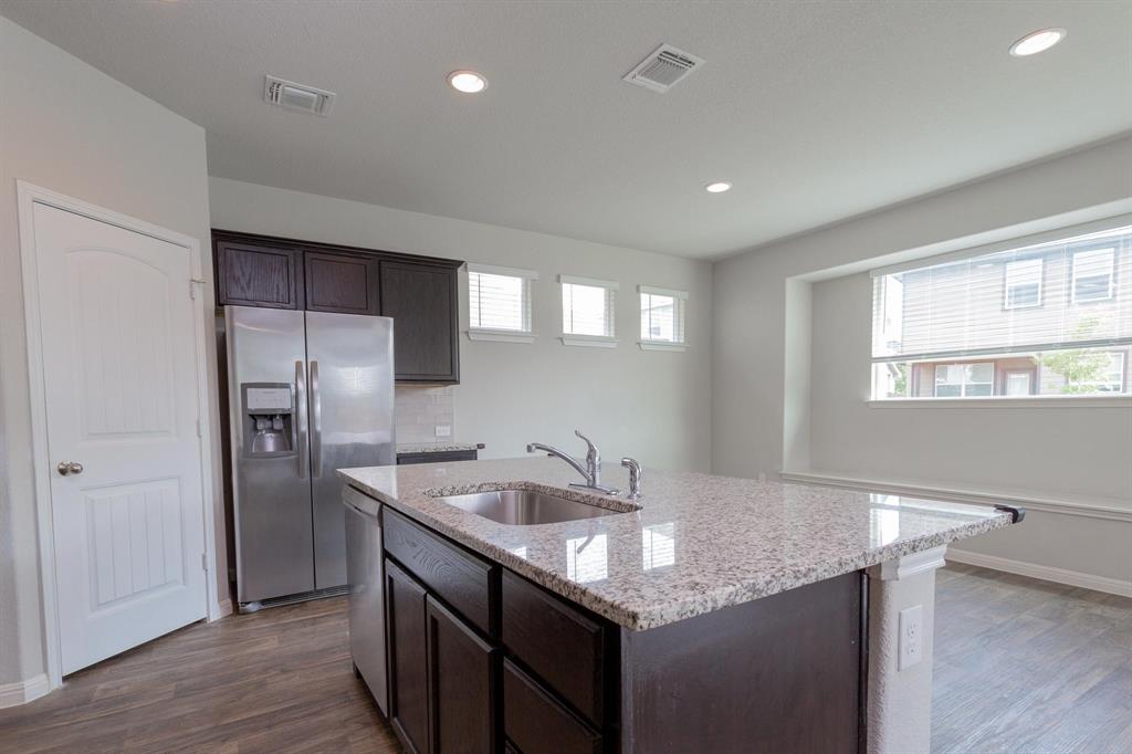 14614 Frankel Loop Pflugerville, TX 78660 - Photo 3 of 15 A sleek island with granite counters commands attention in this modern kitchen.
