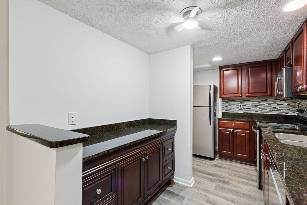 6900 Roswell Road, Unit Q6 Atlanta, GA 30328 - Photo 13 of 38 a kitchen with granite countertop stainless steel appliances and wooden cabinets