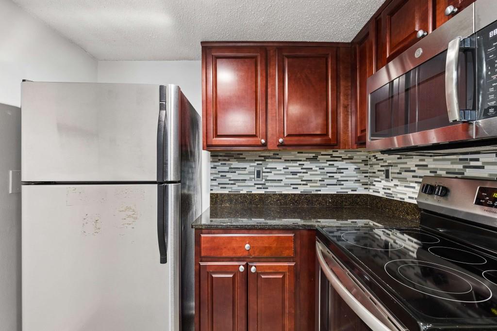 6900 Roswell Road, Unit Q6 Atlanta, GA 30328 - Photo 16 of 38 a kitchen with a refrigerator and a stove top oven