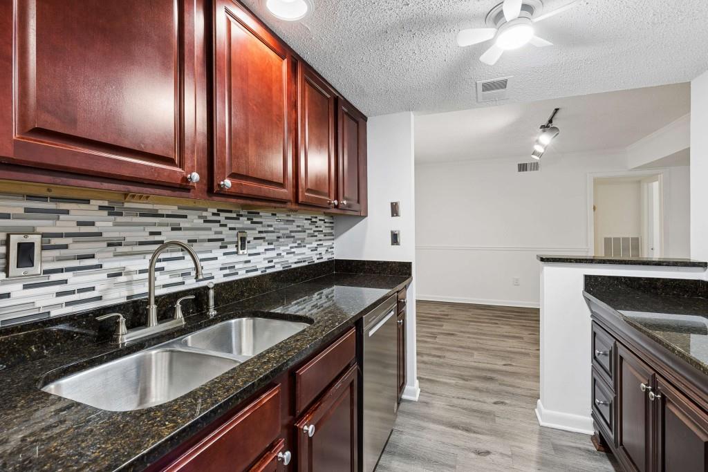 6900 Roswell Road, Unit Q6 Atlanta, GA 30328 - Photo 18 of 38 a kitchen with granite countertop a sink stove and cabinets