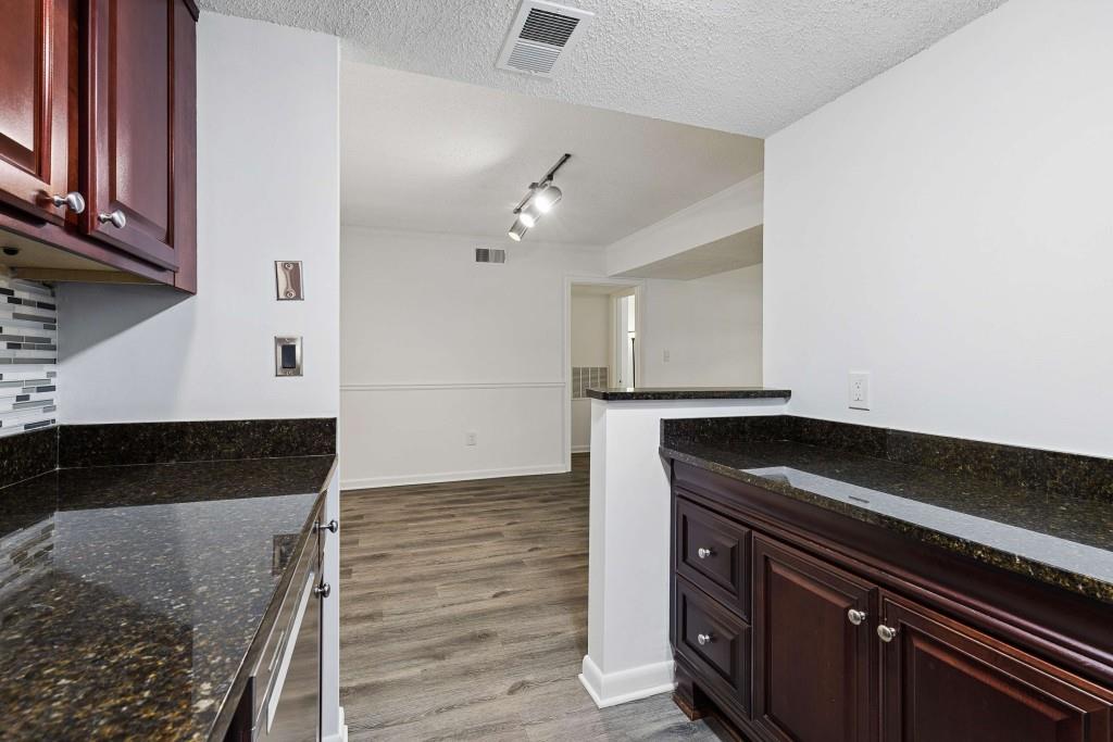 6900 Roswell Road, Unit Q6 Atlanta, GA 30328 - Photo 19 of 38 a view of kitchen with granite countertop cabinets and flat screen tv