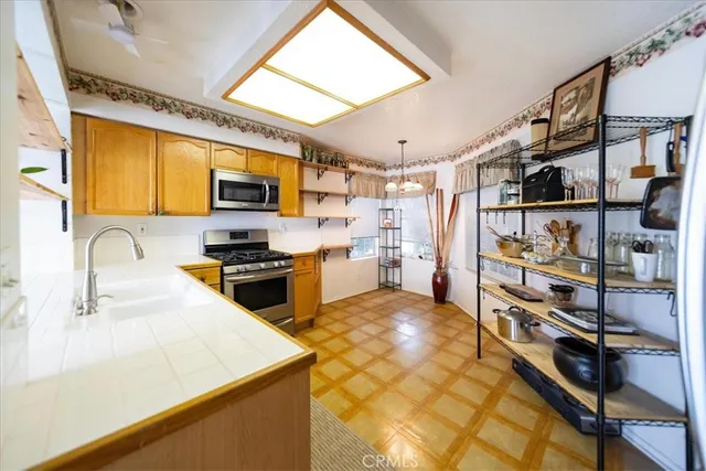 a kitchen with stainless steel appliances a stove a sink a microwave and cabinets