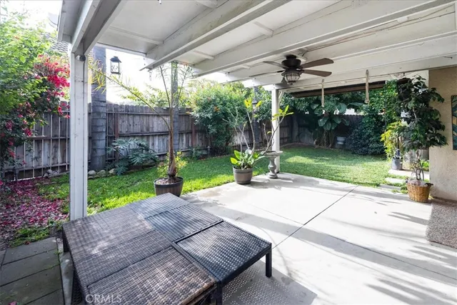 a view of a patio with table and chairs potted plants and large tree