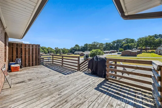 a backyard of a house with wooden floor outdoor seating and kitchen view