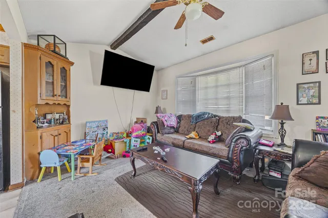 a living room with furniture a flat screen tv and a window