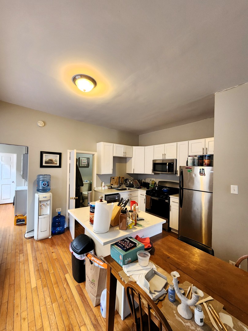 973 West 19th Street, Unit 3 Chicago, IL 60608 - Photo 2 of 10 a living room with stainless steel appliances furniture and a wooden floor