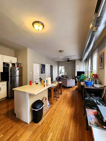 a large room with kitchen island a large counter top space a sink stainless steel appliances and cabinets