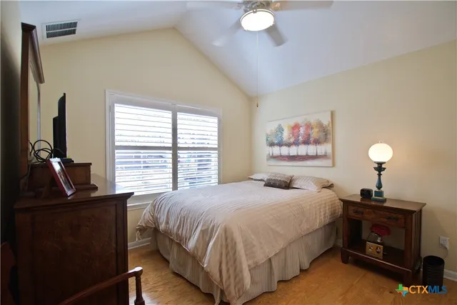 a bedroom with a bed and a flat tv screen on dresser