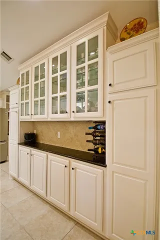 a kitchen with white cabinets and sink