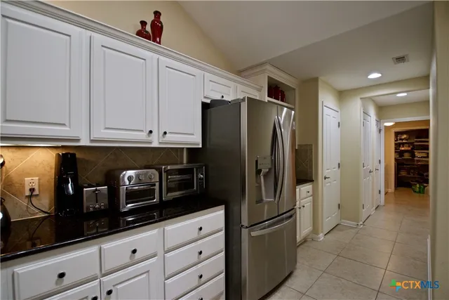 a kitchen with stainless steel appliances granite countertop a refrigerator and a stove top oven