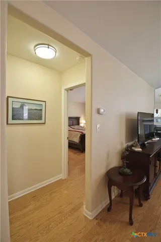 a hallway with a computer on the desk and chair