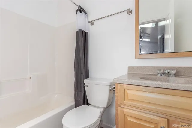 a bathroom with a granite countertop toilet sink and mirror