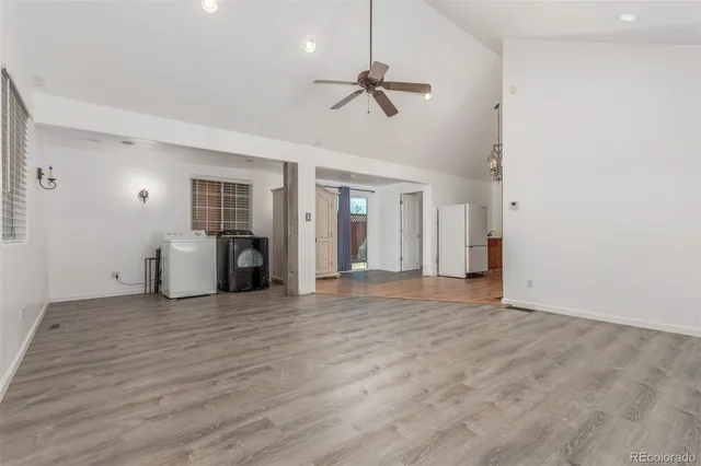 a view of a livingroom with wooden floor and a ceiling fan