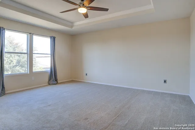 an empty room with a ceiling fan and window
