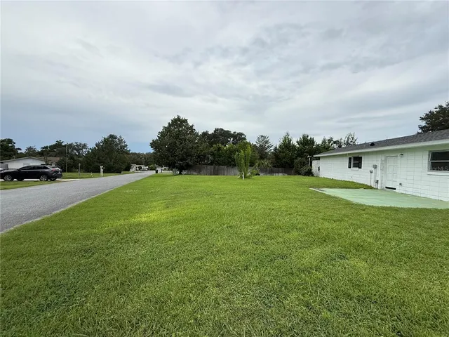 a view of a green field with wooden fence