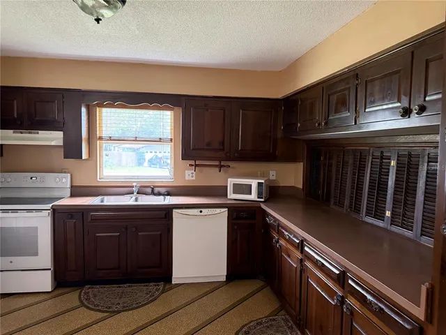a kitchen with stainless steel appliances granite countertop a sink stove and cabinets