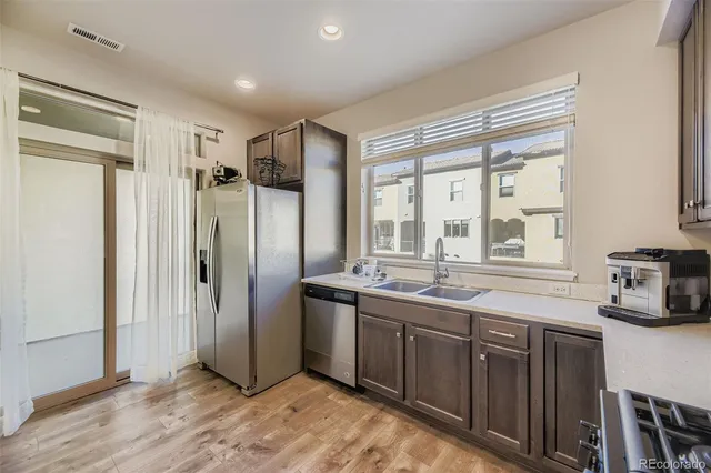 a kitchen with stainless steel appliances granite countertop a refrigerator and a sink