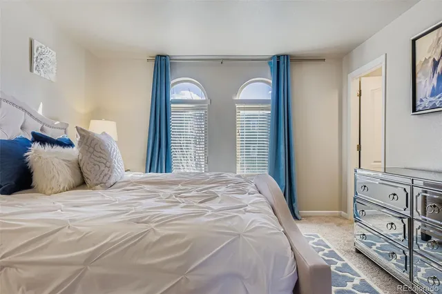 a large white bed in a bedroom next to a window