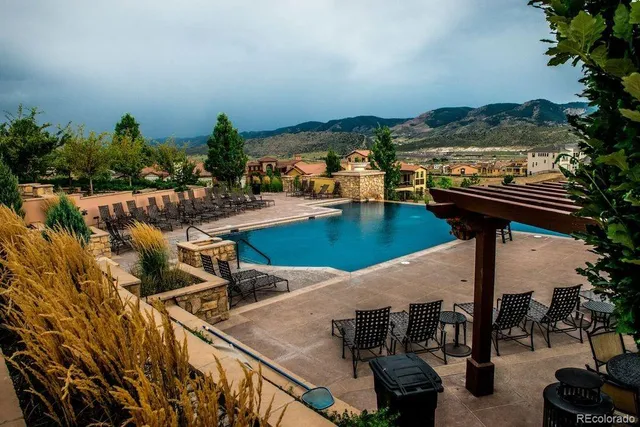 a view of swimming pool with seating area and lake view