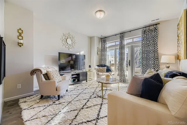 a living room with furniture a flat screen tv and a large window