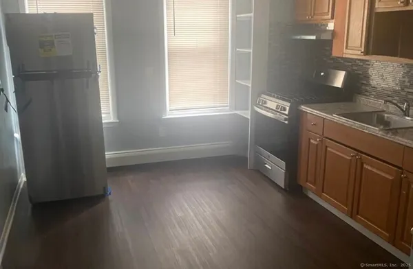 a view of a kitchen with wooden floor and electronic appliances